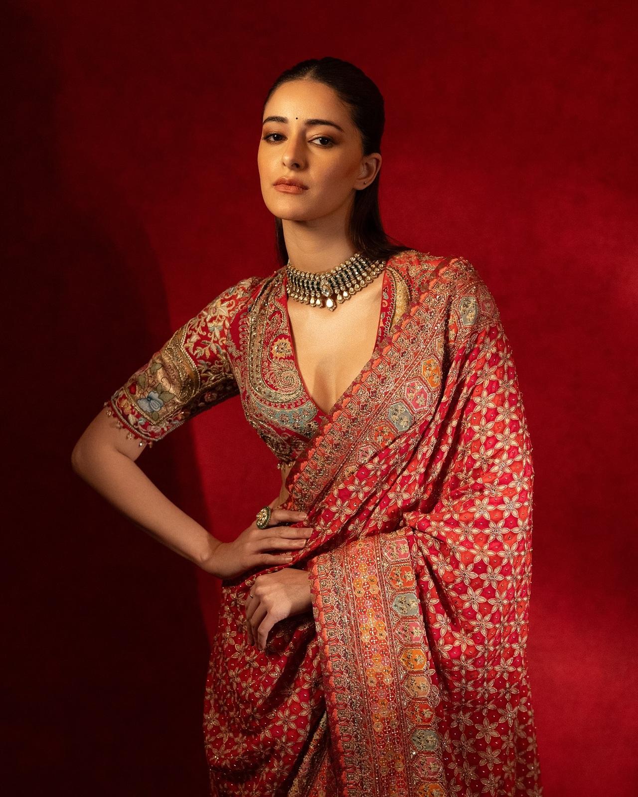 Ananya Panday looks gorgeous in this stunning red saree by Tarun Tahiliani — a perfect pick for the modern bride-to-be. The saree features detailed embroidery and a mix of traditional patterns. She styled it with a heavy blouse, statement choker, sleek hair, and minimal makeup.